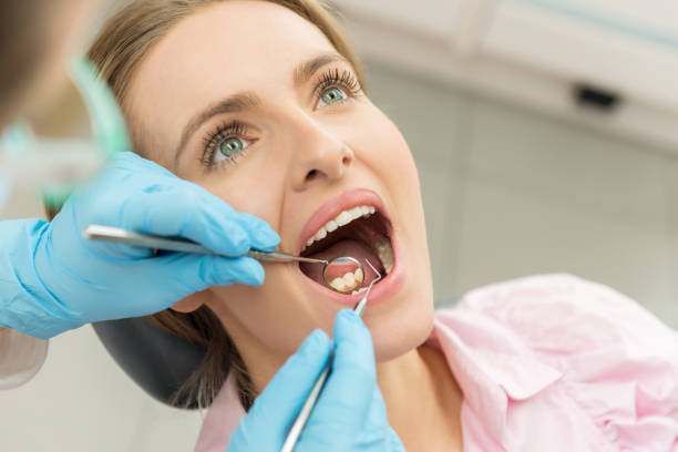 Horizontal color close-up headshot of beautiful woman having dental examination.